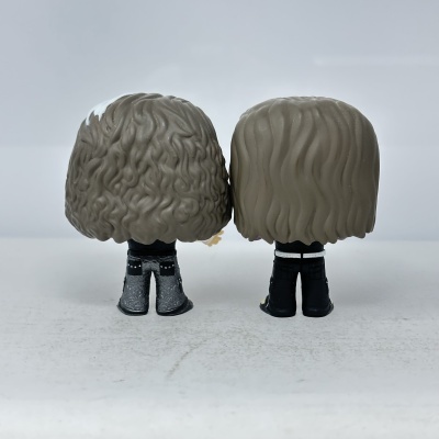 Duas figuras Funko Pop vistas de trás com cabelo castanho e roupas detalhadas