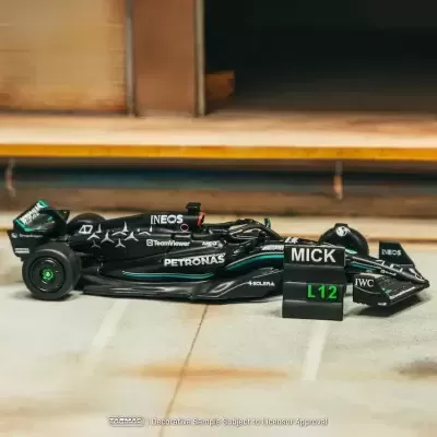 Miniatura de carro de Fórmula 1 preto com inscrições em branco e placa preta escrita MICK e L12 em verde