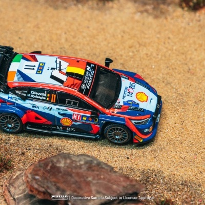 Miniatura de carro de rali Hyundai azul, vermelho e branco com logótipos sobre terra batida