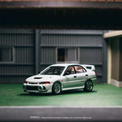 Miniatura de carro desportivo branco em cenário industrial.