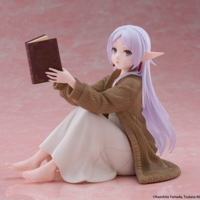Figura colecionável de personagem feminina sentada a ler um livro com fundo rosa.