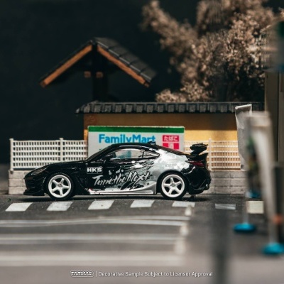Miniatura de carro desportivo preto e branco numa miniatura de parque de estacionamento