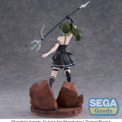 Figura colecionável anime com roupa preta segurando lança em base com rochas