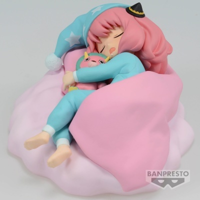 Figura de menina em pijama azul a dormir num colchão rosa com cobertor rosa, segurando almofada colorida