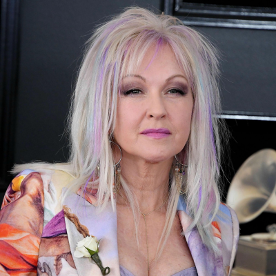 Blazer artístico colorido com flor branca na lapela e acessórios dourados