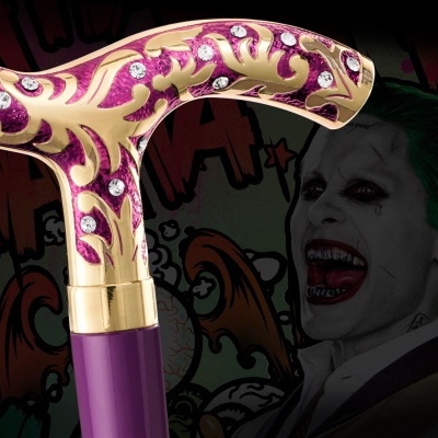 Cabo de bengala roxo e dourado decorado com pedras brilhantes em fundo com arte do Coringa