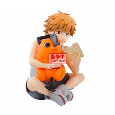 Estatueta de personagem anime sentado com brinquedo laranja e livro