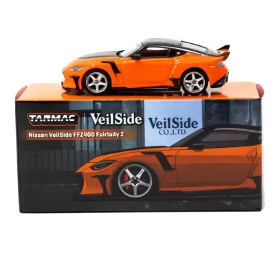 Miniatura de carro desportivo Nissan VeilSide laranja e preto sobre caixa com ilustração do carro