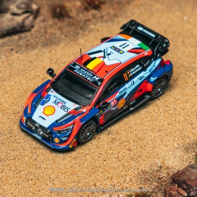 Miniatura de carro de rali Hyundai colorido em terra com pedras e vegetação