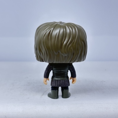 Figura colecionável vista de costas com cabelo castanho e roupa azul escura