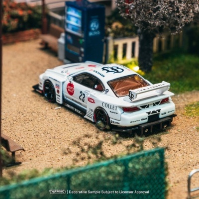 Modelo de carro de corrida branco com vários adesivos e número 23 numa miniatura ao ar livre