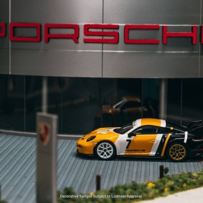 Miniatura de carro de corrida Porsche amarela, branca e preta com número 7