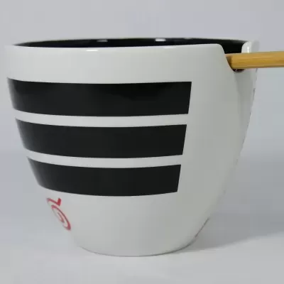 Caneca branca com faixas pretas e pauzinho de madeira