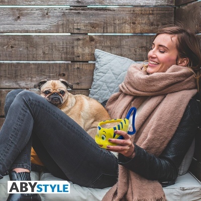 Mulher sentada com cão pug e caneca amarela com padrão azul