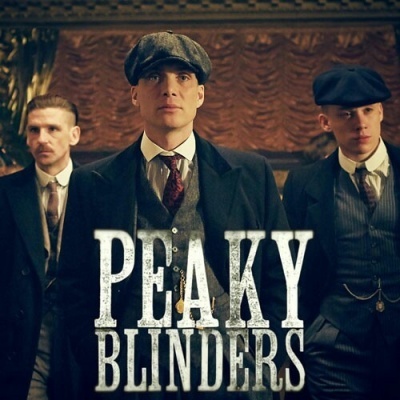 Três homens com fatos clássicos e boinas com texto PEAKY BLINDERS