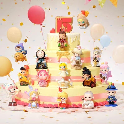 Bolo amarelo de três andares com figuras de personagens coloridas e balões festivos