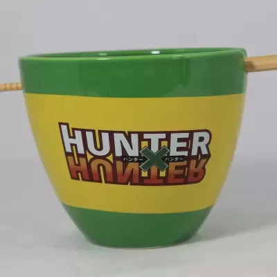 Copo cerâmico verde e amarelo com texto HUNTER e pau de madeira