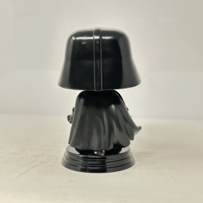 Figura vinyl preta com capacete e capa vista de costas