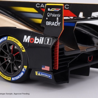 Detalhe de modelo de carro de corrida preto e amarelo com logos de patrocinadores