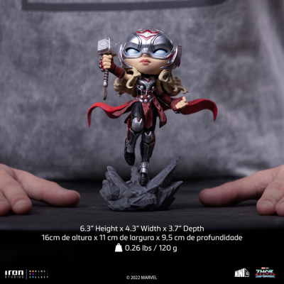 Estatueta de personagem Marvel com armadura prateada e vermelha segurando martelo sobre base de rochas