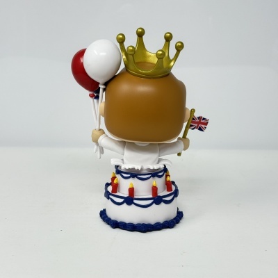 Figura em cima de bolo com balões e coroa dourada