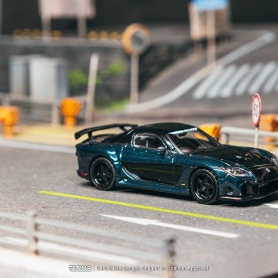 Miniatura de carro desportivo azul metálico num cenário de estrada em miniatura