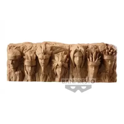 Escultura decorativa em resina com sete rostos humanos em relevo.