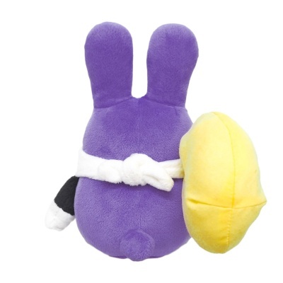 Pelúcia roxa com orelhas de coelho e faixa branca segurando objeto amarelo