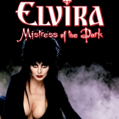 Cartaz da personagem Elvira Mistress of the Dark com cabelo preto e roupa preta decotada, texto em vermelho e branco sobre fundo negro com névoa.