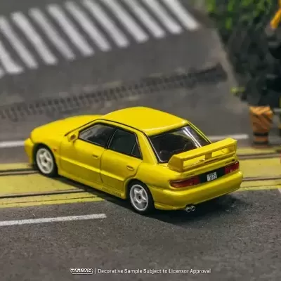 Miniatura de carro desportivo amarelo com spoiler traseiro em estrada de asfalto
