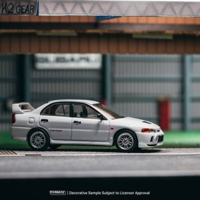 Miniatura de carro de corrida branco com texto EVOLUTION IV e cenário de garagem