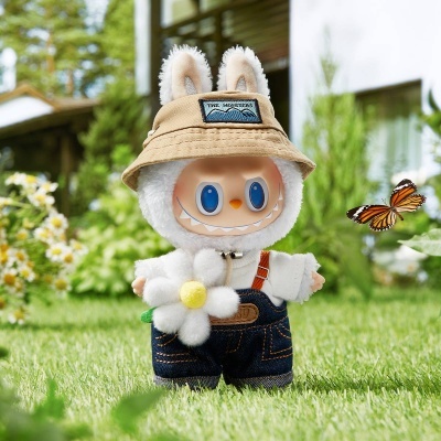 Boneco sorridente com chapéu bege, roupa branca e jeans segurando flor no relvado com borboleta