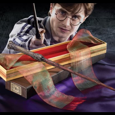 caixa aberta com varinha de madeira e cachecol em tons castanho e verde, jovem ao fundo com varinha