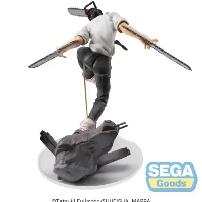 Figura colecionável de personagem com cabeça de motosserra e armas em pose dinâmica, sobre base branca.