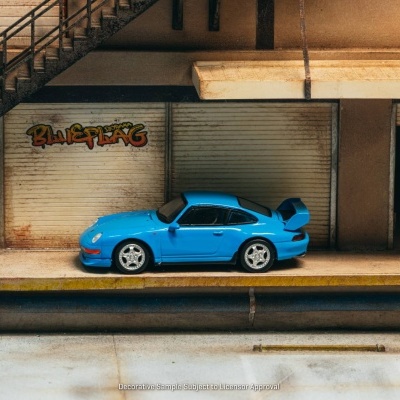 Miniatura de carro desportivo azul com spoiler em frente a porta metálica com graffiti