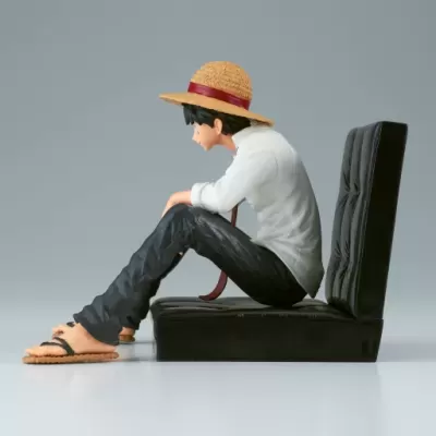Figura de personagem sentado com chapéu de palha e roupa casual em base preta