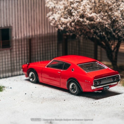 Miniatura de carro desportivo vermelho com jantes prateadas e vedação metálica ao fundo