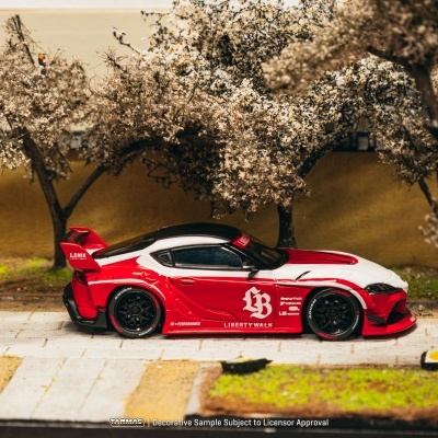 Miniatura de carro desportivo vermelho e branco com árvores artificiais