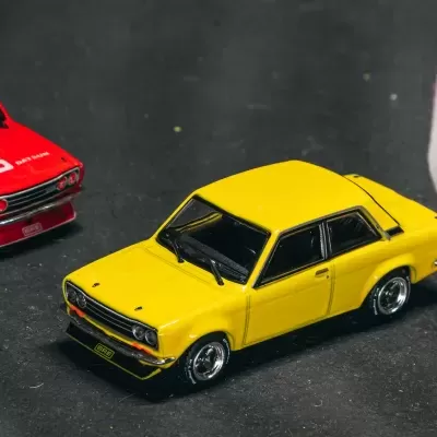 Carros de corrida em miniatura amarelo e vermelho em pista