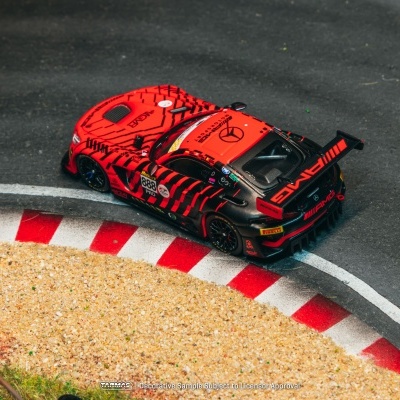 Carro de corrida vermelho com padrões pretos numa pista com limites vermelhos e brancos