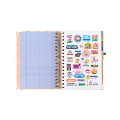 Caderno espiral aberto com página quadriculada e autocolantes coloridos com frases em português