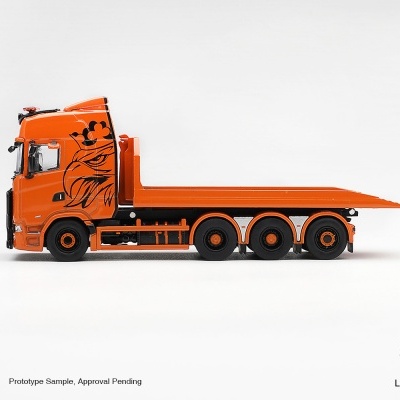 Modelo de camião em miniatura laranja com ilustração preta de águia na cabine.