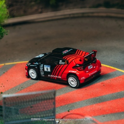 Miniatura de carro de corrida preto e vermelho numa pista de corridas em miniatura