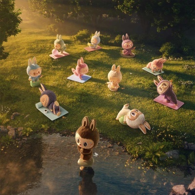 Figuras de coelhos em poses de ioga num relvado perto de um lago