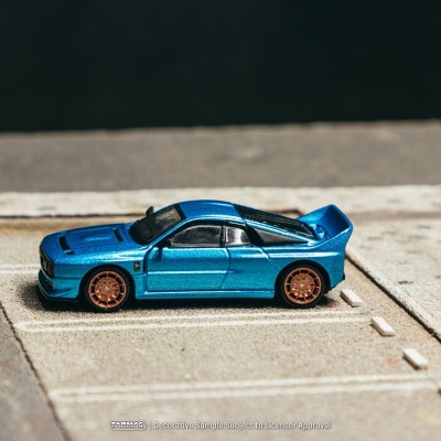 Miniatura de carro desportivo azul com jantes bronze em passeio urbano simulado