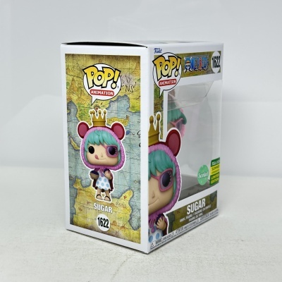 Caixa de brinquedo Funko Pop Animation One Piece Sugar com cabelo verde água, capuz rosa e coroa dourada.