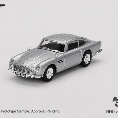 Miniatura de carro clássico prateado com matrícula BMT 216A, fundo cinza claro