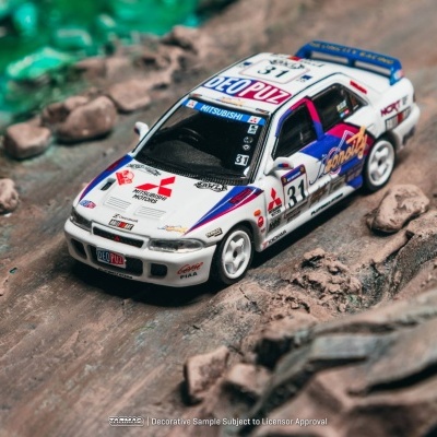 Carro de rali Mitsubishi em miniatura com número 31 e adesivos coloridos em chão com pedras.