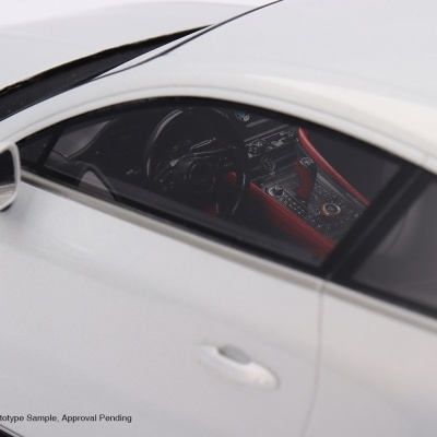 Modelo de carro desportivo branco com interior preto e vermelho visto pela janela