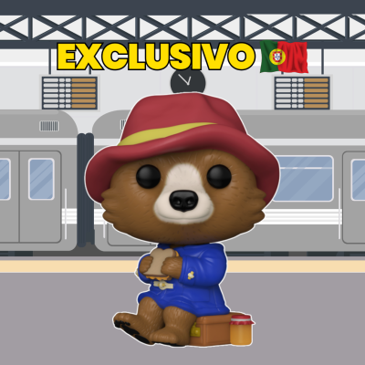 Figura colecionável de urso com casaco azul e chapéu vermelho sentado numa mala numa estação de comboios